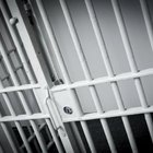 Inmate pressing hand against glass with visitor