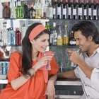 Couple eating melon slices outdoors, looking at each other, laughing