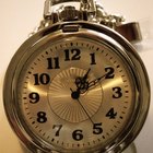 Mid adult man standing at street, looking at watch