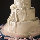 high angle view of a bride and groom cutting the wedding cake