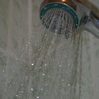 Woman washing long hair in shower under water jet