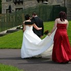 Bride serving wedding cake to pageboy (6-7) and guests