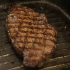 Beef Steak on white dish, plank wood background.