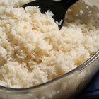 Boiled white rice in ceramic pot on wooden background.