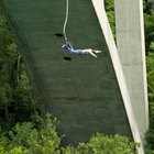 Man bungee jumping, seen against blue sky, view from below