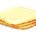 Three golden cheese crackers on wood. With cheese.