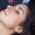 A headshot of a teen Caucasian female using a cleansing pad on her face while looking at the viewer