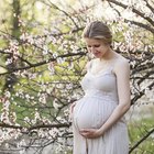 Pregnant young woman looking at her belly