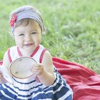 Baby girl (18-24 months) in high chair, spaghetti hanging over tray