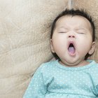 Girl (6-7) yawning in bed, eyes closed, elevated view