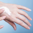 Close-up of a woman's hand applying lotion to her shoulder