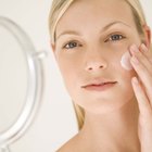 A headshot of a teen Caucasian female using a cleansing pad on her face while looking at the viewer