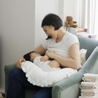 Baby playing with mother in bed