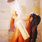 Woman washing long hair in shower under water jet