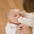 young mother breast feeding her baby girl at sunny day