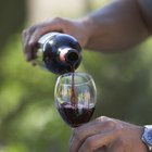 Hand knocking over glass of wine