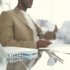 Businessman sitting on chair by laptop on floor, portrait