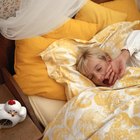 Cheerful girl sleeping with her teddy bear