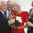 Bride and groom smiling with wedding guests in background