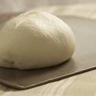 Cook baker prepares bread, focaccia, pizza, buns, sweets. Horizontal photo. Bakery concept, cooking flour products. Design for text.