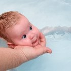 Little boy learning to swim in a swimming pool