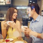 Teenage Couple Stand in Front of a Carousel, Girl Feeding Her Boyfriend Candy Floss and Laughing