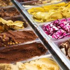 Closeup Cup of Organic Frozen Yogurt Ice cream, Salted Caramel Pecan with fresh strawberry and chocolate candy in a plastic takeaway on blurred background.