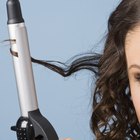 Woman straightening hair with straightener.