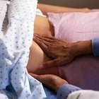 Woman feeling sick and stomachache lying in bed