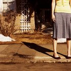 Girl (10-11) standing on roundabout in playground,low section