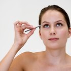 Portrait of girl plucking eyebrows with tweezers