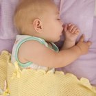 Cute sleeping newborn baby child on mother hands