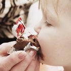 Cute baby with heart shaped lollipop at park