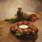 Crock-pot hot wings on a platter with ranch dressing and celery sticks