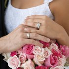 close-up of a groom putting a ring on his bride's finger