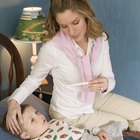 Closeup of caring mother holding head on sick daughter forehead