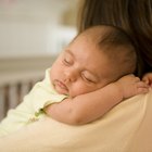 Close-up of a newborn baby sleeping on the bed