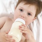 relationship portrait of a young mother as she feeds her newborn baby