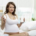Schöne junge schwangere Frau lächelt