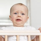 Close-up of a young mother changing the nappy of her baby lying on a couch