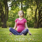 Beautiful pregnant woman laying on grass