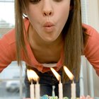 Friends throwing streamers over woman holding cake