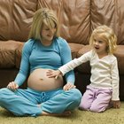 Pregnant young woman reading paperwork, side view