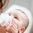 baby with small bottle in bed