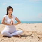 Pregnant woman sitting on mat in touching her belly