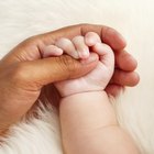 Father's hands holding his newborn with love,