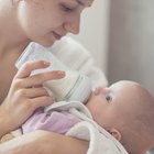 Mother feeding baby with milk bottle