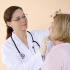 A headshot of a teen Caucasian female using a cleansing pad on her face while looking at the viewer