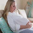 Attractive pregnant woman holding a bowl of salad while standing