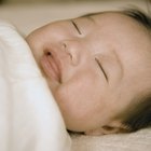 Cute sleeping newborn baby child on mother hands